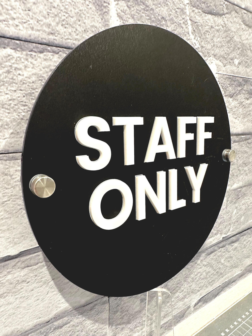 Wall-mounted matte black acrylic STAFF ONLY door sign with a modern white 3D acrylic lettering. Features silver standoff fixings for easy installation. Available in multiple colourways. Ideal for businesses, restaurants, offices, public washrooms