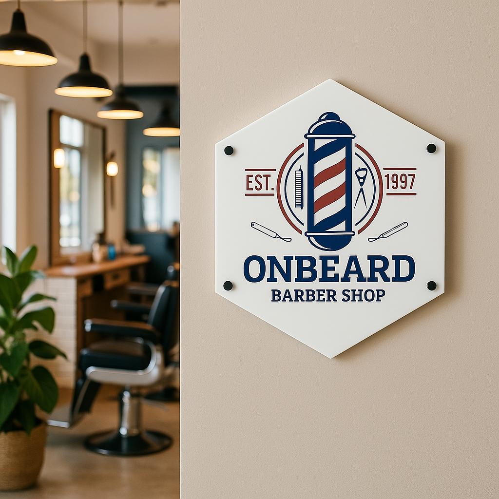 Hexagon-shaped barber shop sign featuring a vintage-style barber pole graphic in red, white, and blue. The text on the sign reads 'ONBEARD BARBER SHOP', 'EST. 1997', and includes images of barber tools. The sign is white with dark blue and red accents. It's displayed on a dark gray textured wall, next to a vase of pink flowers.